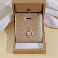 Detail of a gold clover necklace with purple heart gems in a premium jewelry gift box - X3342 Purple Necklace
