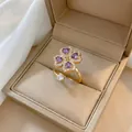 Macro detail of gold clover ring with purple heart-shaped zircons and white crystals - J0282 Purple Ring