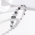 Detailed shot of silver bangle featuring alternating black and white square-cut zircons - Black