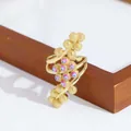 Detalle del anillo dorado 18K con cuentas de ojo turco sobre un marco de madera - Púrpura