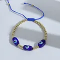 Close-up of blue braided evil eye bracelet with 18K gold beads and adjustable cord - Dark Blue