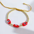 Detailed shot of handmade adjustable evil eye bracelet with 18K gold plated copper beads - Red