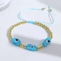Detail of 18K gold-plated beads and blue evil eye charms on adjustable cord bracelet - Sky Blue
