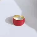 Detail of wide open ring featuring red embossed texture and polished gold inner surface - Red