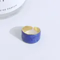 Vista de detalle de anillo ancho ajustable con esmalte jaspeado azul e interior dorado - Azul marino