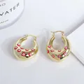 Detailed macro view of 18K gold-plated hoop earrings with colorful evil eye enamel patterns - Red