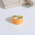 Anillo ancho abierto con textura de mármol naranja y detalles de metal dorado pulido - Naranja