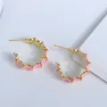 Vista de detalle de pendientes de aro ondulados bañados en oro 18K con esmalte rosa - Rosa
