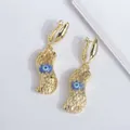 Detalle macro de pendientes de cacahuete bañados en oro 18K con ojo azul y textura - Azul marino