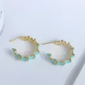 Détail macro de créoles plaquées or 18 carats avec bordure ondulée en émail turquoise - Vert Lac