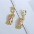 Vista macro de pendientes de cacahuete en oro de 18K con detalle de ojo esmaltado - Rosa