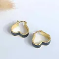 Detalle de pendientes de aro de corazón bañados en oro de 18K con esmalte negro y S925 - Negro