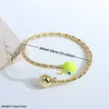 Twisted gold-plated cuff with yellow evil eye charm showing 59mm diameter detail - Yellow