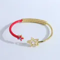 Primer plano de pulsera mal de ojo bañada en oro de 18K con esmalte rojo y detalle de estrella - Rojo