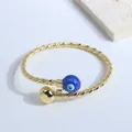 Detailed view of gold twisted rope cuff bracelet with blue evil eye and polished bead - Dark Blue