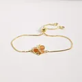 Détail du bracelet papillon doré ajustable avec émail orange et incrustation de zircons - Marron