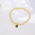 Detailed macro view of 18k gold plated beaded bracelet with emerald green zircon pendant - August (Peridot Zirconia)
