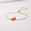 Detalle de la pulsera de mariposa dorada con alas de esmalte rojo y circonita incrustada - Rojo