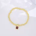 Detail of 18k gold beaded bracelet featuring a square red zircon birthstone pendant - January (Garnet Zirconia)