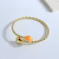 Twisted rope 18K gold plated cuff bracelet featuring a bright orange evil eye bead - Orange