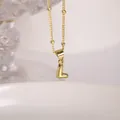 Macro shot of 18K gold letter L pendant on a delicate beaded satellite chain necklace - Letter L