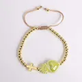 Detalle de pulsera de cuentas doradas con colgantes de corazón verde y cruz sacra - Verde Oscuro