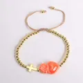Detalle de pulsera de cuentas de oro de 18K con cruz y colgante de corazón naranja - Naranja