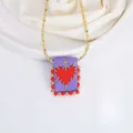 Detalle de cadena de oro 18K con colgante rectangular tejido a mano y motivo de corazón - Púrpura