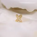 Golden letter X pendant with sparkling cubic zirconia pavé on white silk background - Letter X