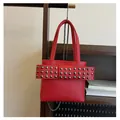 Nahaufnahme der roten Umhängetasche mit Lychee-Struktur, Nieten und Metallkette - Rot