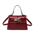 Deep red patent leather trapezoid handbag with metal clasp and adjustable shoulder strap - Red