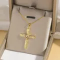 Golden cross necklace with colorful zircons and engraved details in a velvet jewelry box - Gold