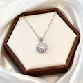 Close-up of a silver flower necklace with rotating zircon pendant in a brown jewelry box - Rotating Necklace / Steel