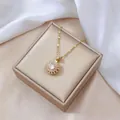 Close-up of a rotating flower pendant with sparkling zircon on a luxury jewelry box - Rotating Necklace / Gold