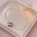 Bracciale a quadrifoglio dorato regolabile con zirconi viola a cuore su portagioie - Quadrifoglio Viola (TS0526) / Viola