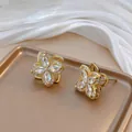 Close-up of golden four-leaf flower earrings with zircon petals and micro-pave crystals - Four-leaf Earrings (E0003) / Gold Earrings