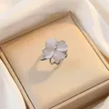 Close-up of elegant four-leaf clover pendant with white cat-eye stones on silver base - Rotating Opal Ring (J0067)