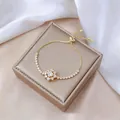Primer plano de la pulsera ajustable de oro con estrella de circón en satén blanco - Pulsera de Zirconia (TS0466)