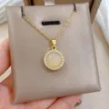 Detail of a rotating cat eye stone pendant with zircon halo on a gold titanium chain - Gold Tone Rotating Necklace (X0064)