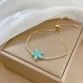 Dettaglio del bracciale dorato regolabile con fiore blu e pietre di zircone marquise - Bracciale Blu
