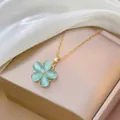 Dettaglio di una collana con ciondolo a fiore verde con catena oro e zirconi - Set Collana e Bracciale Blu
