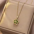 Detailed macro view of rotating green zircon flower pendant on a thin gold chain necklace - Emerald Bauhinia Rotating Style (X1310)