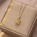 Macro detail of rotating gold flower pendant with pink stones on a jewelry box - Pink Bauhinia Rotating Style (X1310)