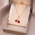Detailed macro view of cherry pendant necklace with red stones in champagne jewelry box - Steel Color Red Cherry