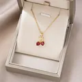 Elegant gold cherry necklace with red heart crystals on champagne silk background - Red Heart Gemstone Cherry (X4162)