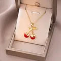 Détail du pendentif cerise rouge sur chaîne dorée dans un coffret cadeau de luxe - Or Cerise Rouge