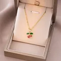 Détail du collier cerise avec pierres roses et vertes dans son coffret cadeau chic - Zirconium Rose Feuille Verte Cerise