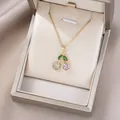 Macro shot of cherry pendant with green marquise stones and sparkling crystals - Two-Tone Gemstone Cherry (X0027)