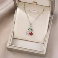 Detaillierte Ansicht des silbernen Kirsch-Anhängers mit Edelstein in einer Geschenkbox - Rote Facettierte Edelstein Weiße Zirkonia Kirsche (X0009)