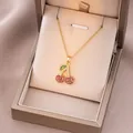 Macro detail of gold cherry pendant with red and green cubic zirconia on a cable chain - Gold Colorful Cherry